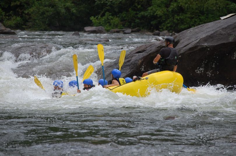 people doing rafting on mountain river
